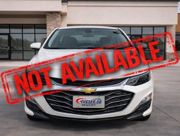 Front view of a white Chevrolet sedan parked outdoors.