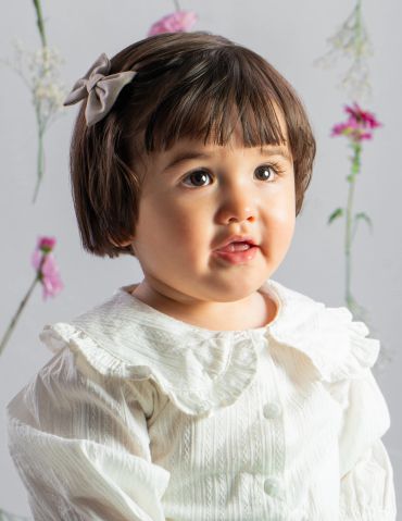 Portrait of a little girl with a bow in her hair.