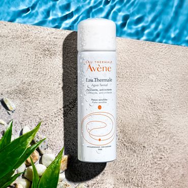 Producto Avène para cuidado facial junto a una piscina.