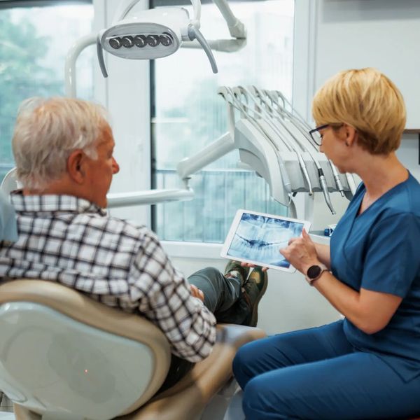 Dentist showing X-ray to patient in clinic