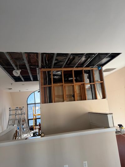 Interior room under construction with exposed ceiling and wooden framing.