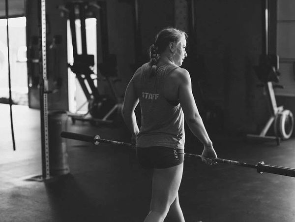 woman walking with a barbell
