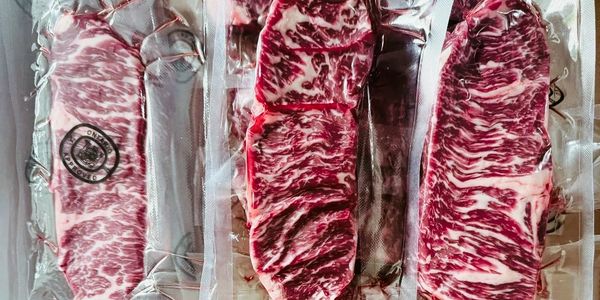 Three vacuum-sealed marbled meat cuts, labeled with Ontario approval stamps.