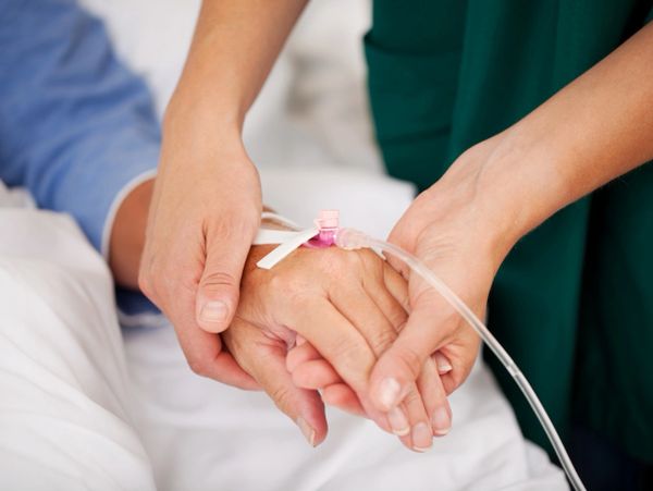 A nurse holding her patient's hand
