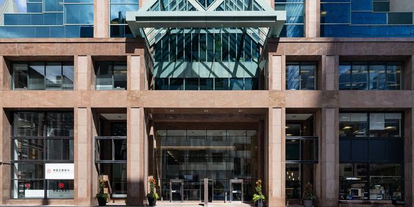 Overall street facade with all-glass entrance and existing colonnade with canopy skylight.