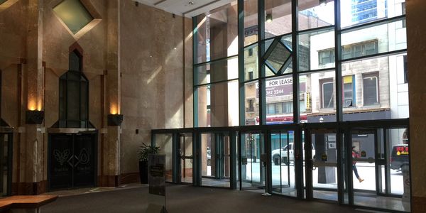 The existing office building lobby looking through an aluminum storefront with vestibules.