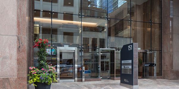 Exterior view of the all-glass entrance with stainless steel entry portals.