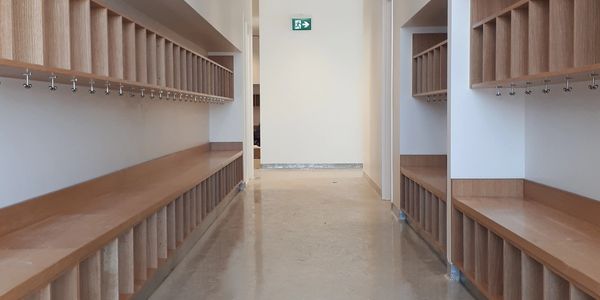 White painted corridor with warm stained wood cubbies.