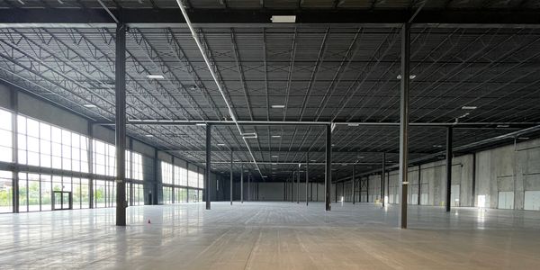 Interior photo of a very long, vacant  warehouse space before constructing the demising wall
