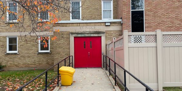 Entrance ramp to community hall with fenced play area.