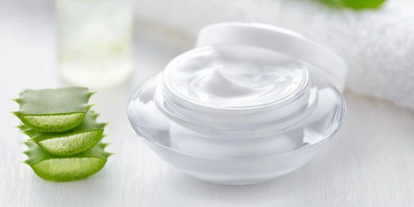 Aloe vera cosmetic cream with herb slices skin face and body care