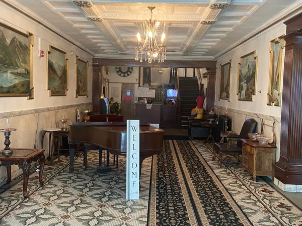 Elegant lobby with piano and chandelier.