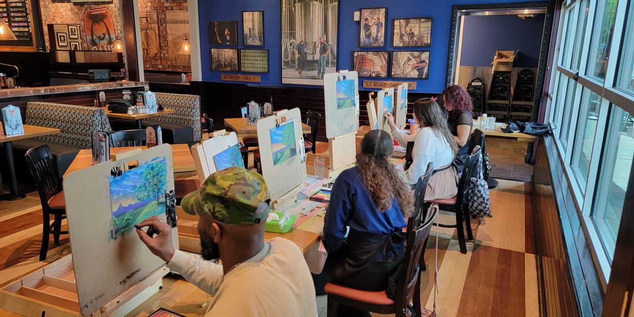 People engaged in a painting class at a cozy art studio.