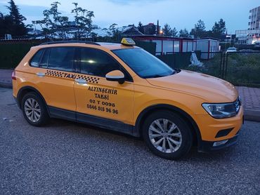 Yellow taxi parked on a street at dusk.