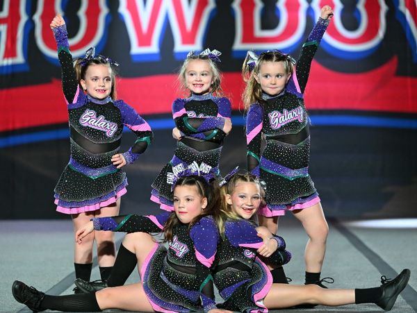 Young cheerleaders in matching Galaxy uniforms pose confidently during a competition.