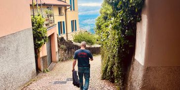 Man walking down a cobblestone street in a picturesque village.