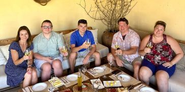 A group of five people enjoying drinks and appetizers together.