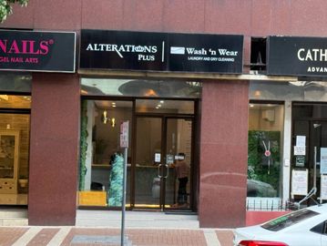 Storefronts including alterations and laundry services in an urban setting.