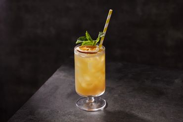 Yerba Mate Iced tea in a tall glass with a mint garnish. Changshu & Xingfu