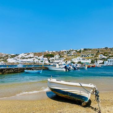 A row boat in Mykonos, Greece. Blue Sky, clear waters, waves