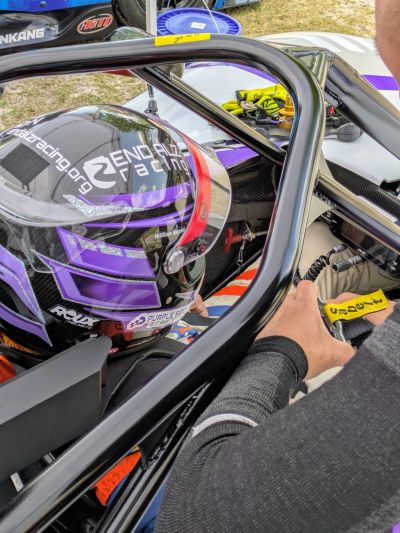 Race car driver preparing in cockpit.
