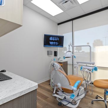 Modern dental office with a chair and x-ray display.