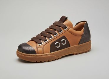 Brown and tan casual sneaker with lace-up design and eyelet details.