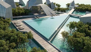 Modern triangular concrete buildings surround a large pool with wooden decks and greenery.