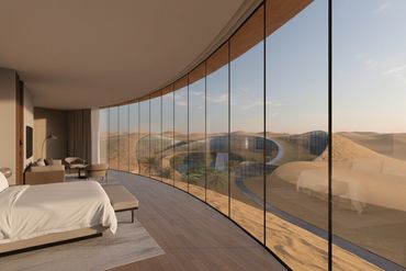 Luxurious bedroom with a panoramic desert view through curved glass walls.