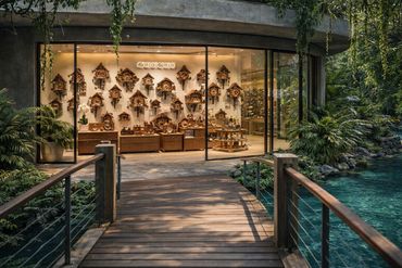 A cozy shop selling wooden cuckoo clocks surrounded by lush greenery and water.