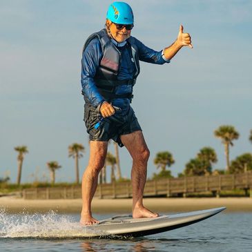 An elderly man enjoying his Fliteboard efoil from Lake House Sports.