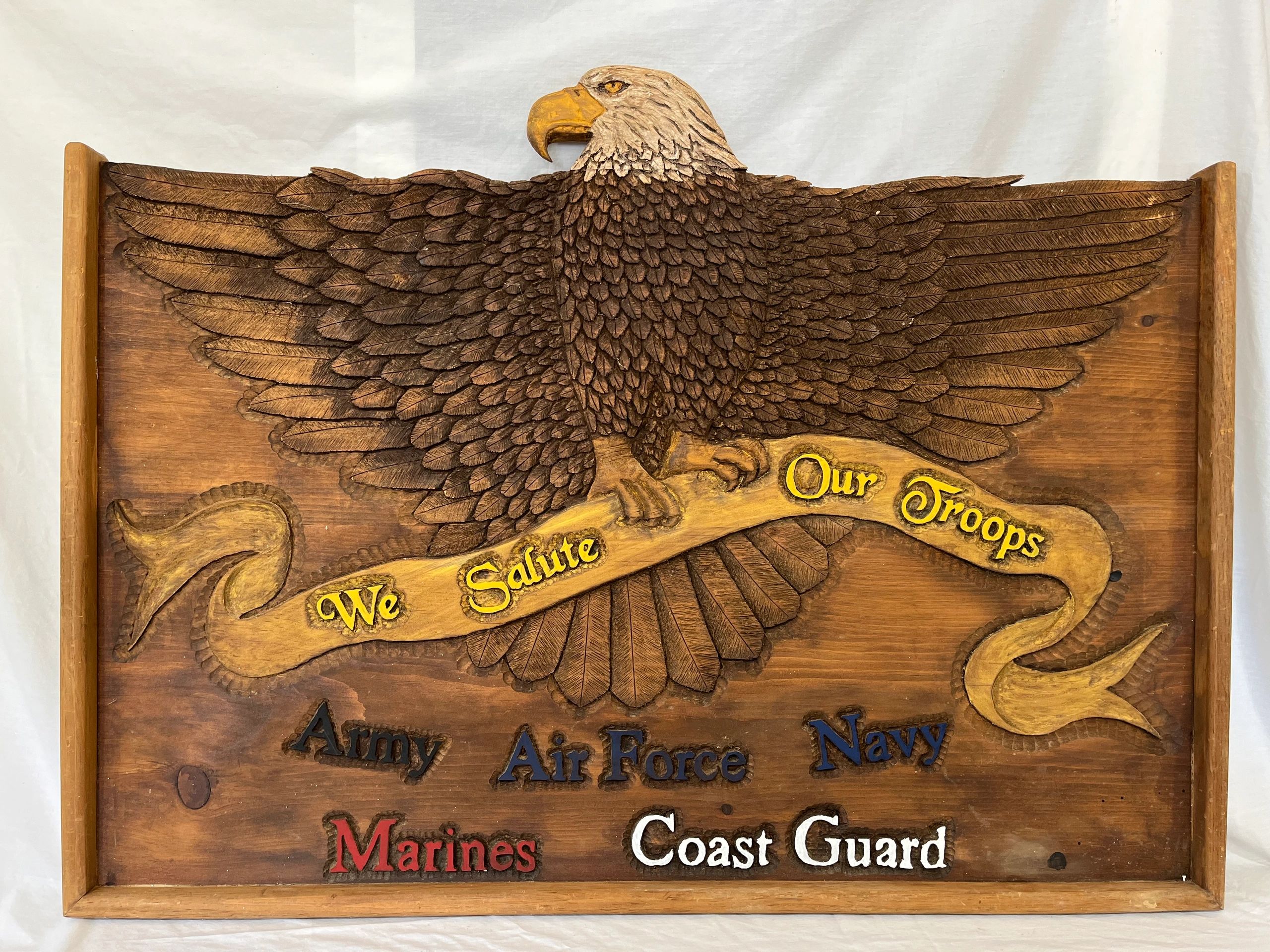 Wood Carving Stating "We Salute to Our Troops"