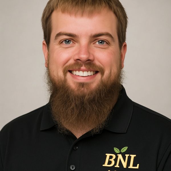 Smiling man with a beard wearing a black BNL polo shirt.
