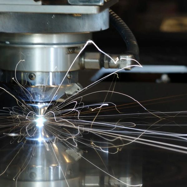 Close-up of a laser cutting machine sparking on metal.