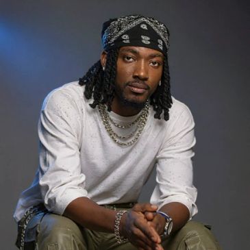 Man with dreadlocks wearing a bandana and white shirt.