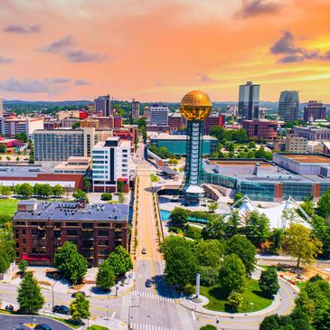 Downtown cityscape with iconic golden globe tower at sunset.