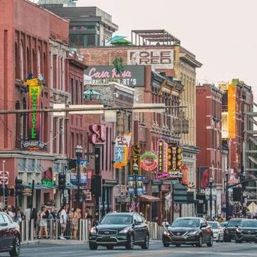 Busy urban street with cars and neon signs.