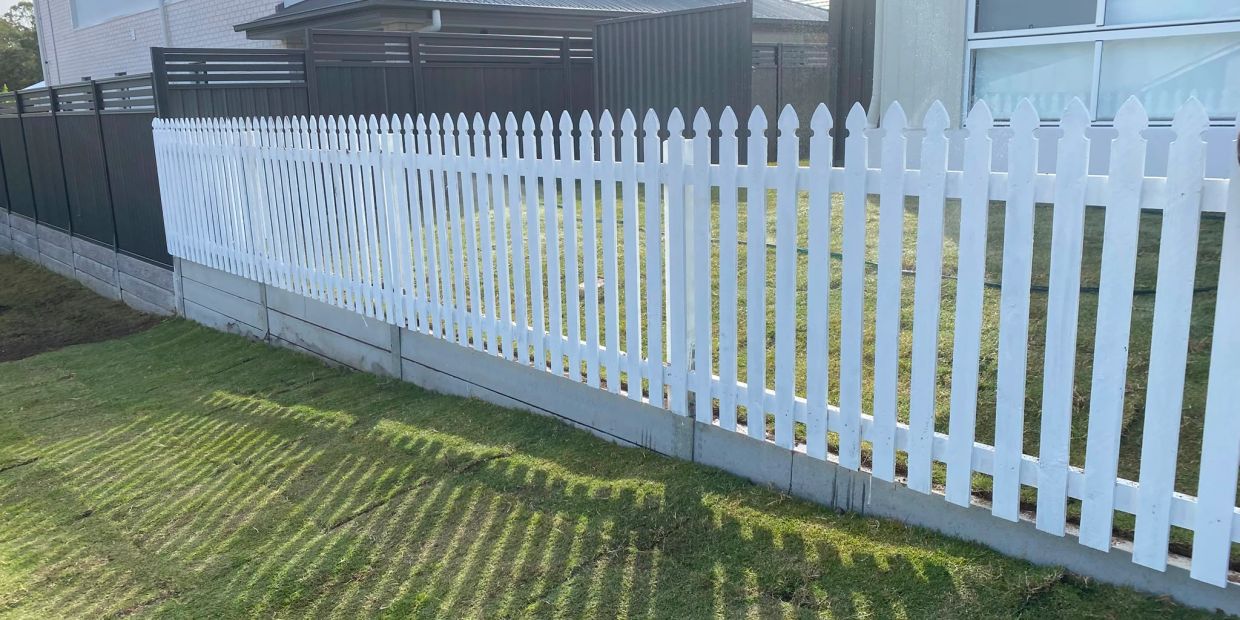 1.2m white picket fence with concrete sleeper retaining wall 