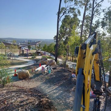 Construction equipment at a park under development with city views.