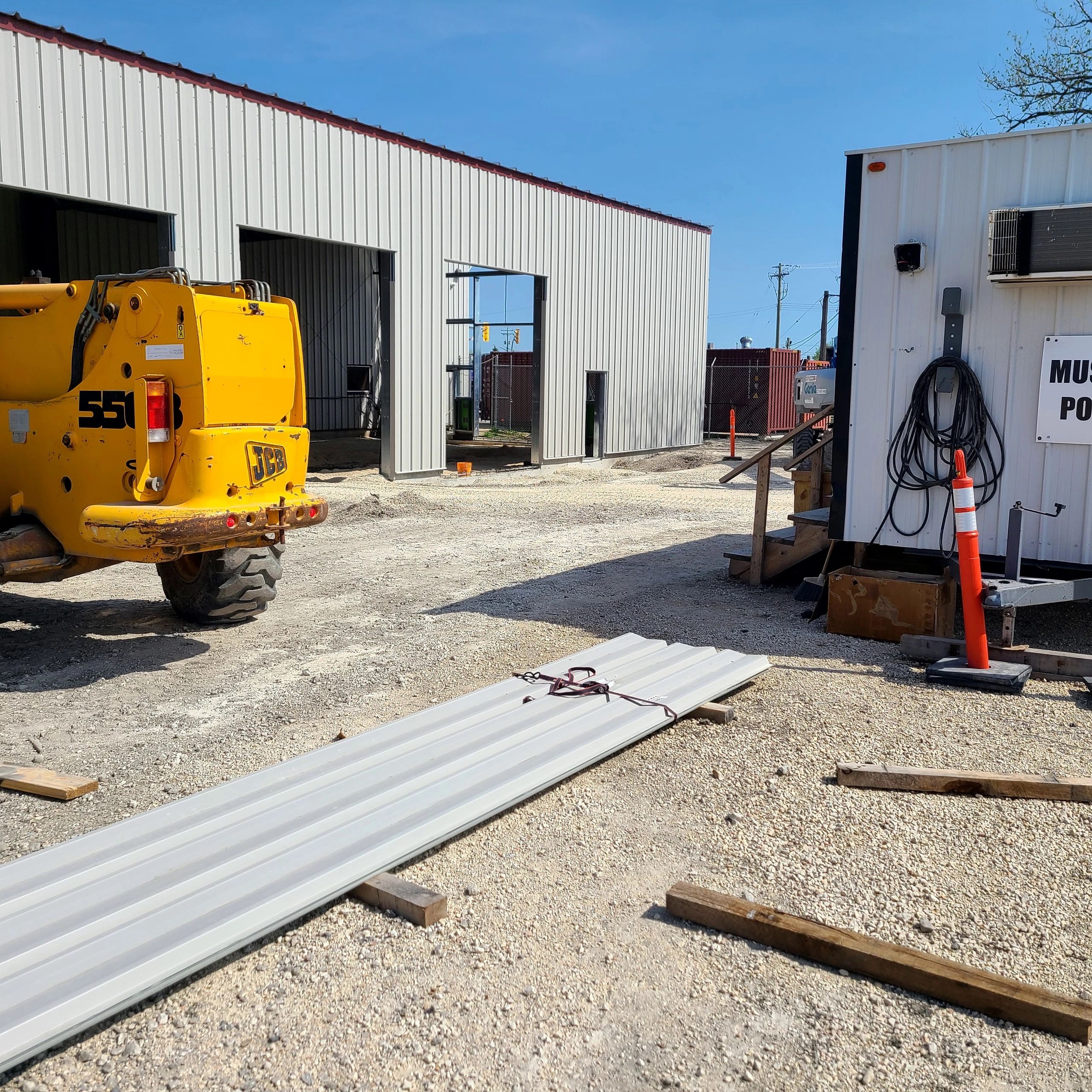 Construction site with equipment and metal sheets.