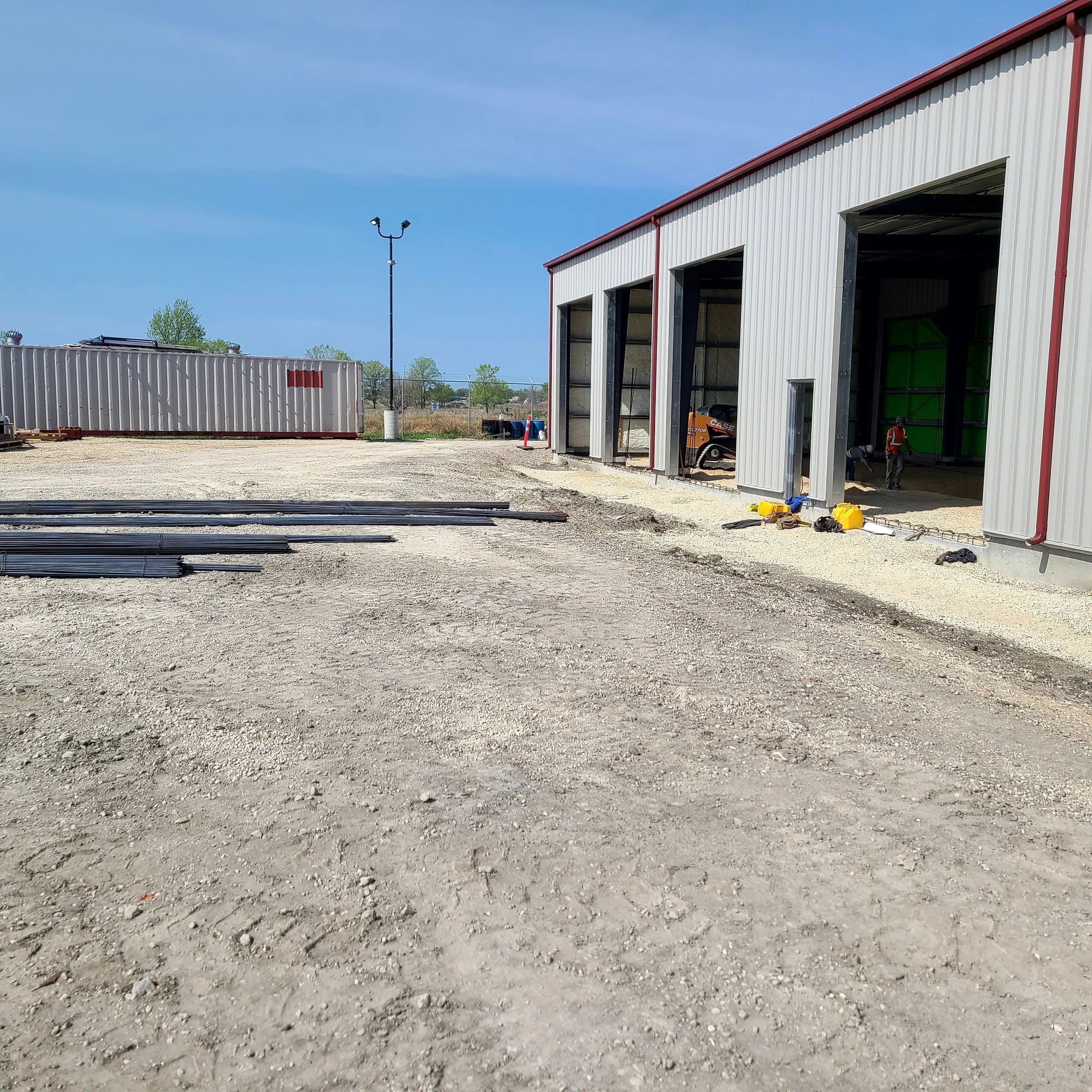 Construction site with warehouse and workers.