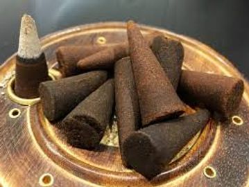 Close-up of incense cones arranged on a decorative holder.