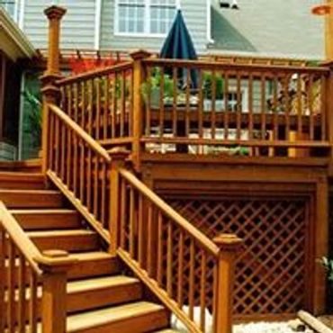 Detailed custom-built wooden deck with columns, railings and stairs with intricate trim work