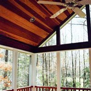 A beautifully stained natural wood ceiling and ceiling fan in a Screened Addition