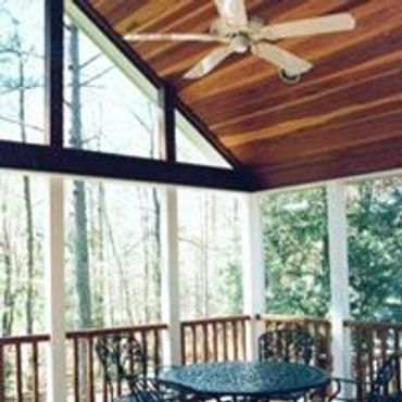 A beautifully stained natural wood ceiling and ceiling fan in a Screened Addition