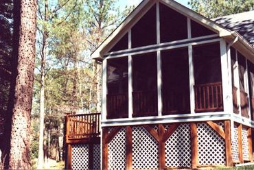 A screened addition with decks and trellis under skirting. 