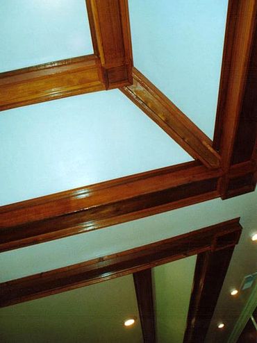 Basement Remodel close-up photo of custom timber-style rafters in tray ceilings with recessed lights