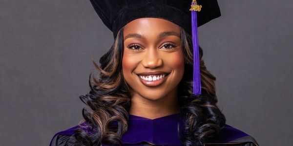 Smiling young woman in graduation attire.
