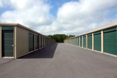 Outdoor storage units with green doors.