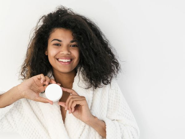 Woman touching face, smiling happily.